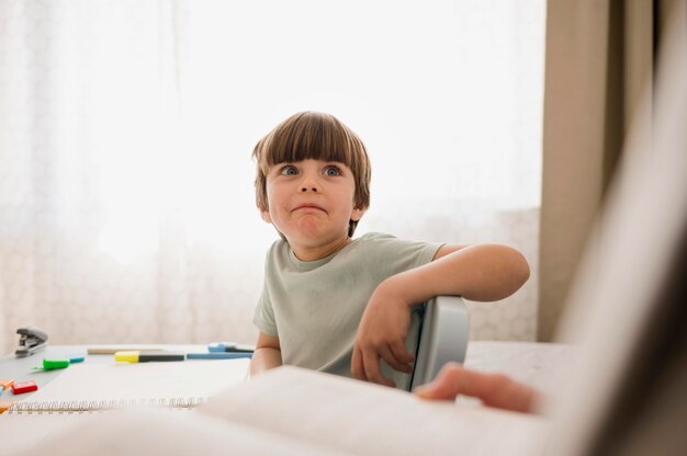 Vista frontal del niño que recibe tutoría en casa