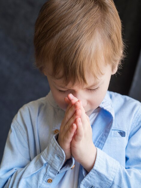 Vista frontal del niño rezando