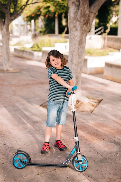 Vista frontal del niño con scooter