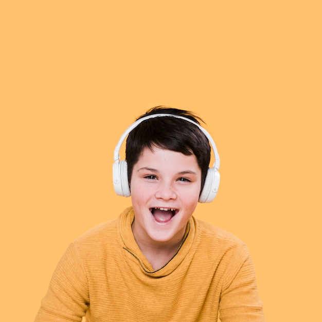 Vista frontal del niño sonriente con auriculares