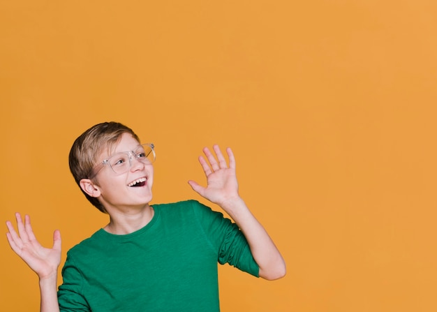 Vista frontal del niño sonriente mirando a otro lado con espacio de copia