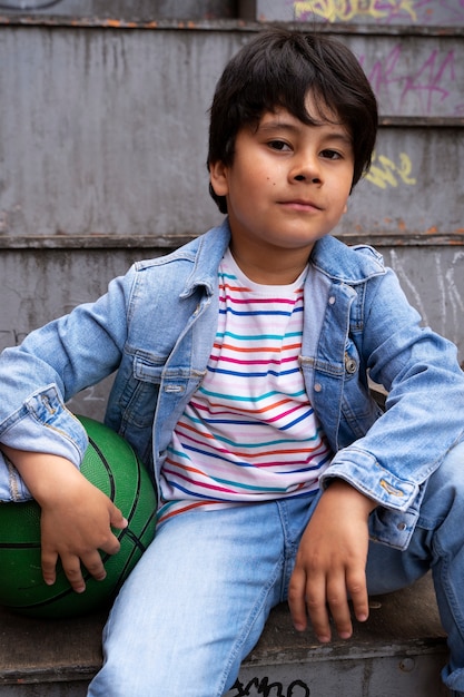 Foto gratuita vista frontal niño sosteniendo pelota