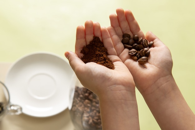 Una vista frontal niño sosteniendo semillas en polvo y café