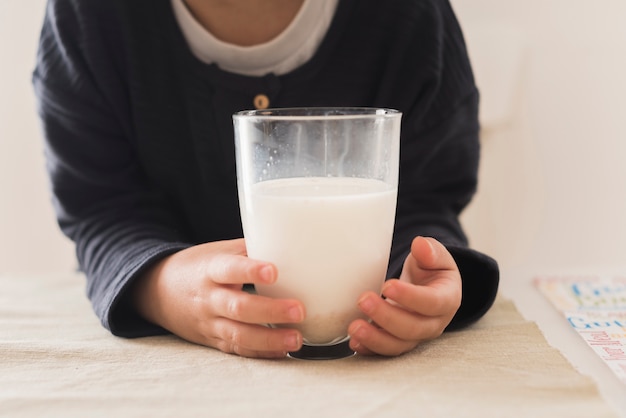 Vista frontal niño sosteniendo un vaso de leche