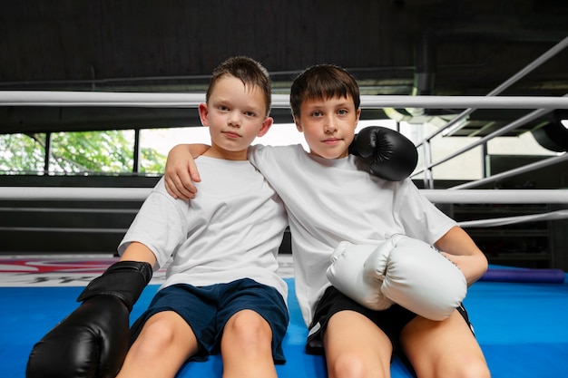 Vista frontal niños aprendiendo boxeo