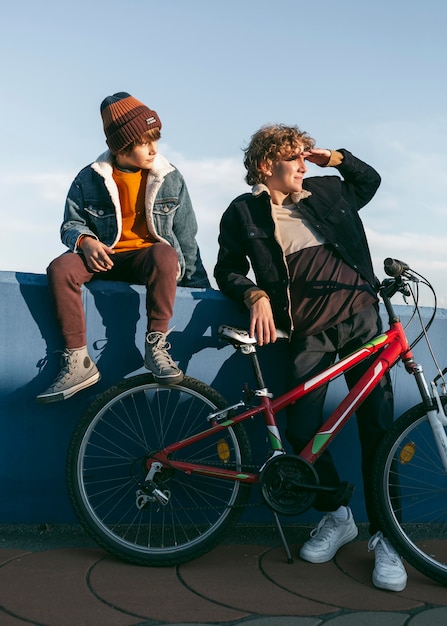 Foto gratuita vista frontal de niños con bicicleta al aire libre.