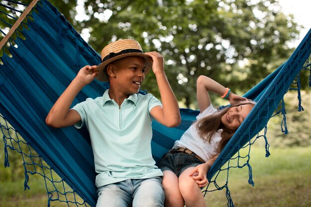 Vista frontal de niños felices en hamaca