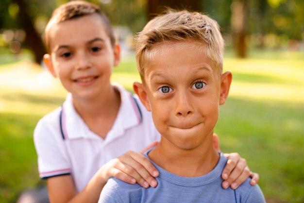 Vista frontal de niños pequeños haciendo caras tontas para la cámara