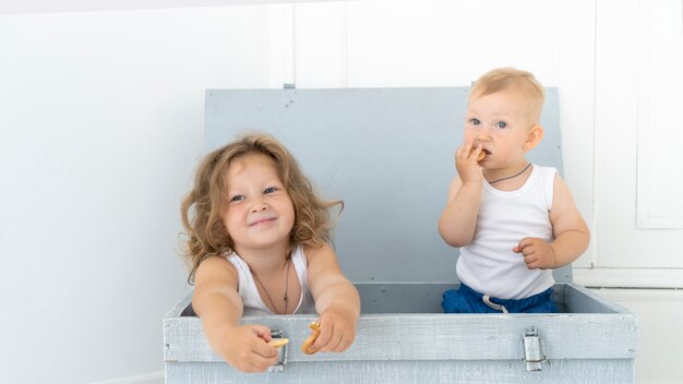 Vista frontal niños sentados en una caja