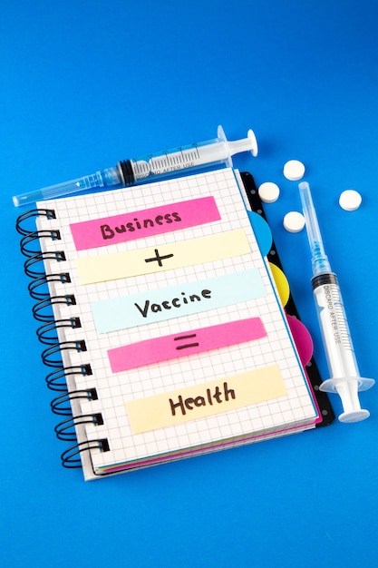 Foto gratuita vista frontal de la nota de salud de la vacuna empresarial con vacuna e inyección sobre fondo azul.