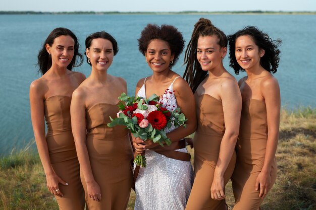 Vista frontal de la novia y las damas de honor en la naturaleza