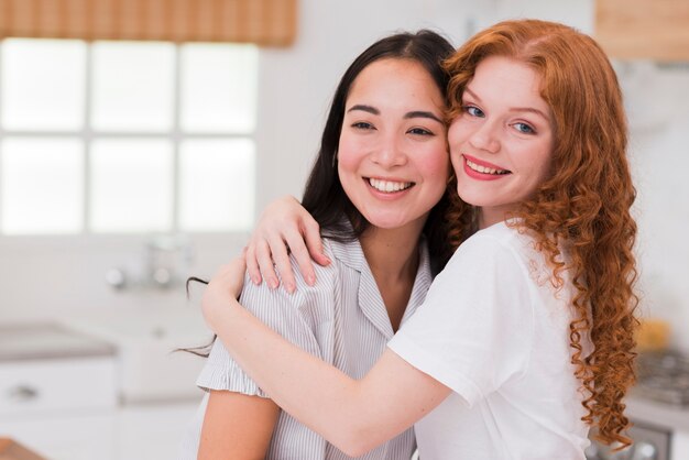 Vista frontal novias sonrientes abrazando