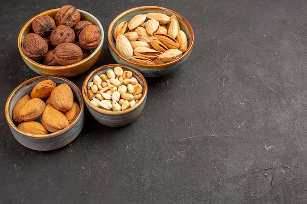 Vista frontal de nueces de composición de nueces y otras nueces en superficie gris