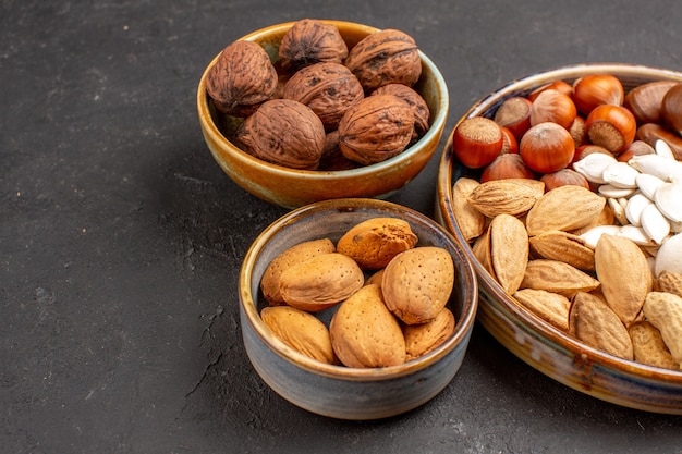 Vista frontal de nueces de composición de nueces y otras nueces en superficie gris