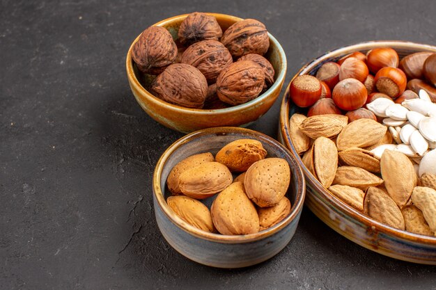 Vista frontal de nueces de composición de nueces y otras nueces en superficie gris