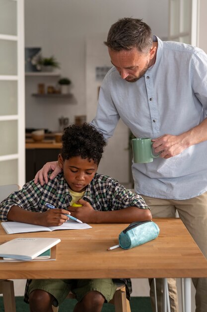 Vista frontal padre ayudando a niño con la tarea