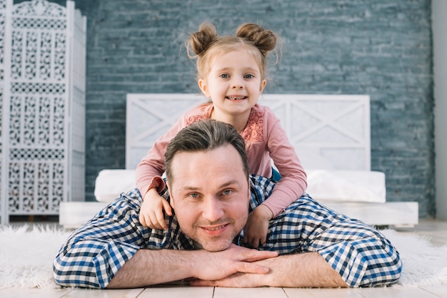 Foto gratuita vista frontal del padre cargando a su hija en casa