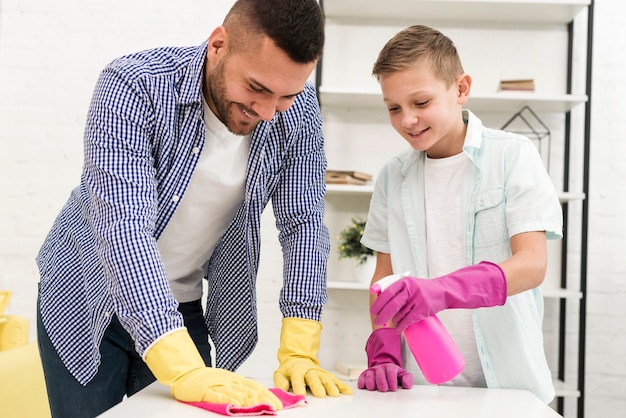 Foto gratuita vista frontal de padre e hijo limpiando la casa