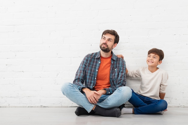 Foto gratuita vista frontal padre e hijo mirando a otro lado