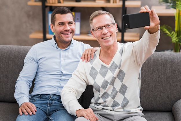 Vista frontal con padre e hijo tomando una selfie