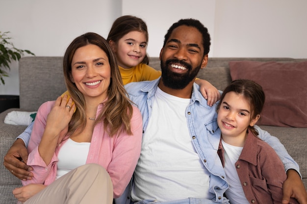 Foto gratuita vista frontal padres felices con niños en casa