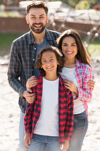 Foto gratuita vista frontal de los padres con el niño posando al aire libre