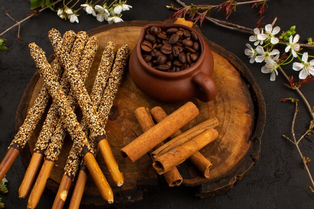 Vista frontal palitos de caramelo junto con café y canela en el escritorio marrón y oscuro