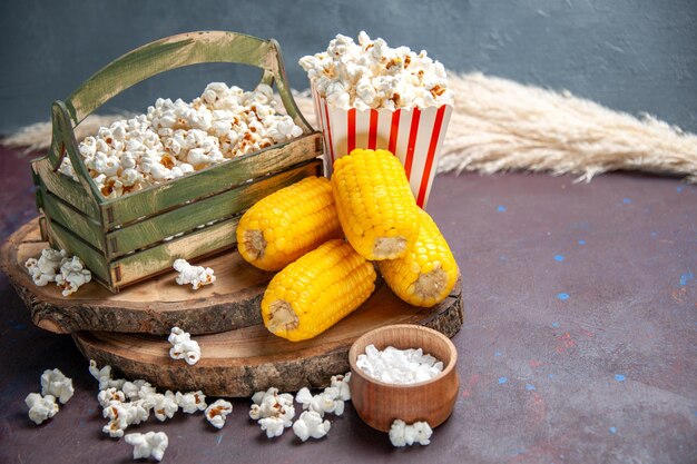 Vista frontal de palomitas de maíz frescas con granos amarillos en la superficie oscura, palomitas de maíz, alimentos, maíz