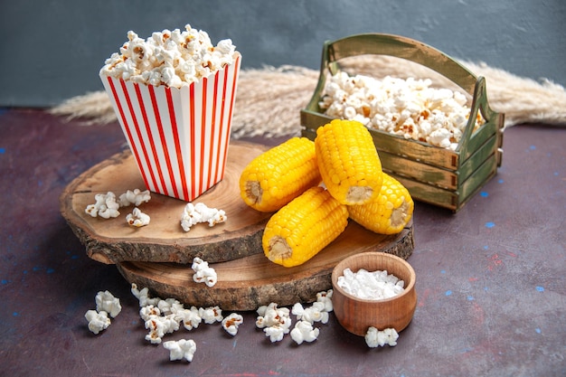 Foto gratuita vista frontal de palomitas de maíz frescas con granos amarillos en la superficie oscura, palomitas de maíz, alimentos, maíz