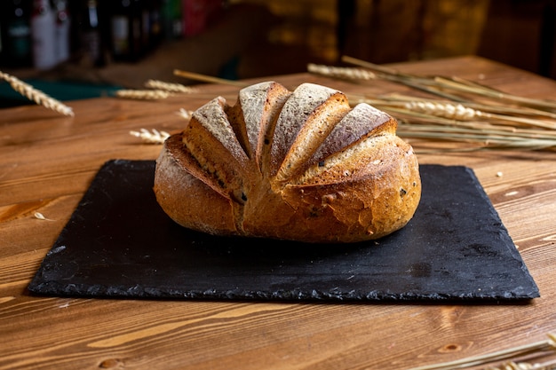 Una vista frontal pan blanco entero panadería al horno sabroso apetito en el tejido negro aislado masa de hojaldre