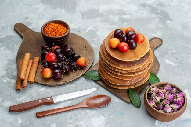 Una vista frontal de panqueques redondos horneados y deliciosos con fruta de pastel de cerezas