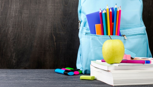 Vista frontal de papelería de regreso a la escuela con lápices de colores y manzana