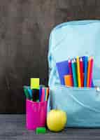 Foto gratuita vista frontal de papelería de regreso a la escuela con lápices de colores y manzana