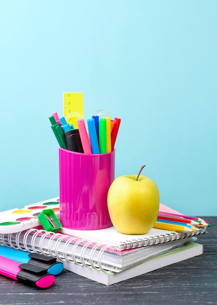 Vista frontal de papelería de regreso a la escuela con manzana y cuadernos