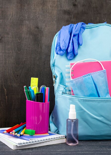 Vista frontal de papelería de regreso a la escuela con mochila y guantes