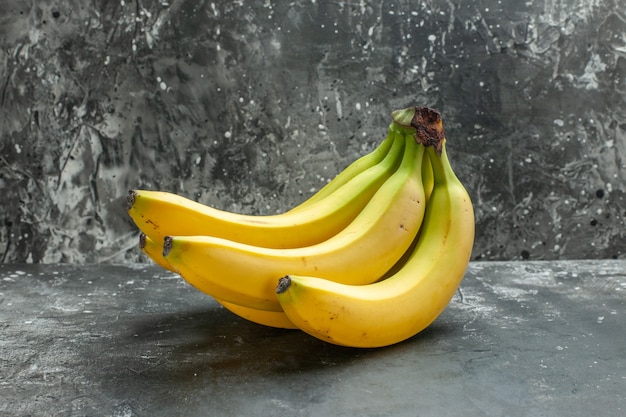 Vista frontal del paquete de bananas frescas de fuente de nutrición orgánica sobre fondo oscuro