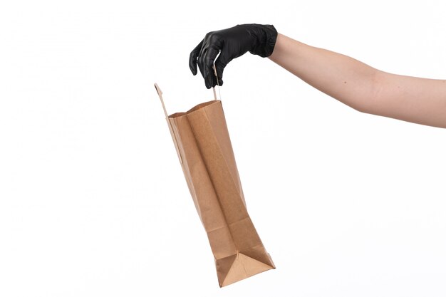 Una vista frontal paquete de papel vacío espera por hembra en guantes negros sobre blanco