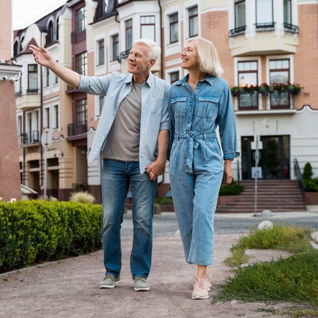 Vista frontal de la pareja de ancianos dando un paseo por la ciudad