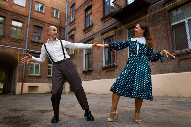 Vista frontal pareja bailando al aire libre