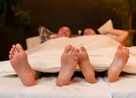 Foto gratuita vista frontal de la pareja en la cama descalzo