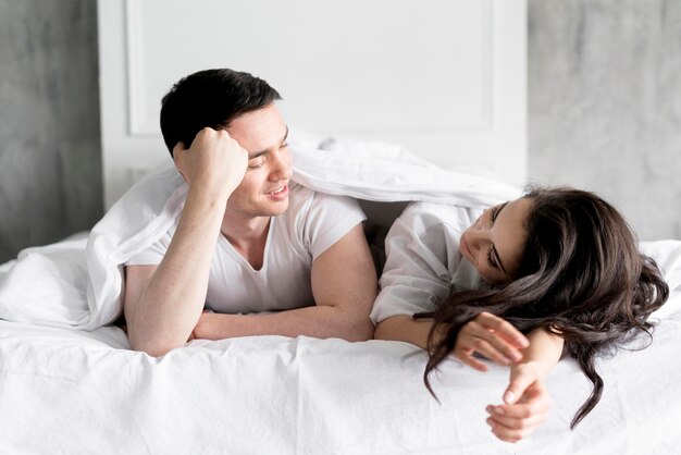 Vista frontal de la pareja en la cama en su casa