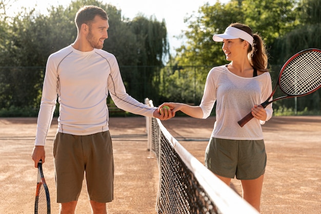 Vista frontal pareja en cancha de tenis