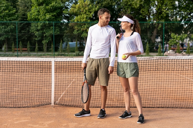 Vista frontal pareja en cancha de tenis
