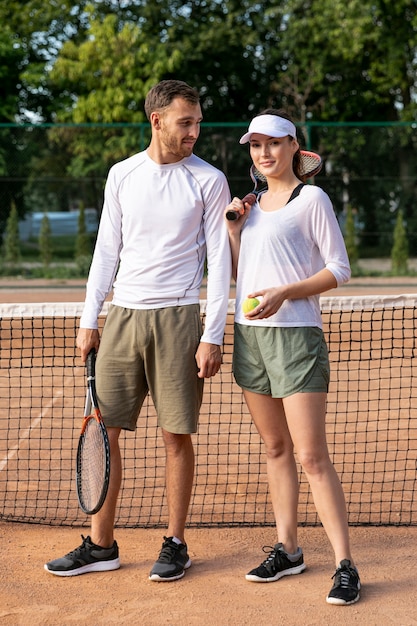 Vista frontal pareja en cancha de tenis