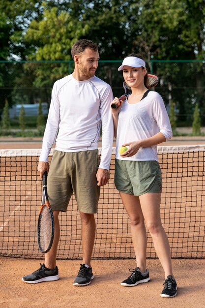 Vista frontal pareja en cancha de tenis