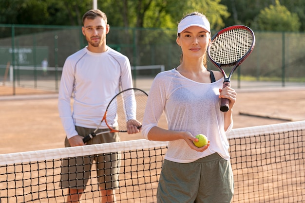 Foto gratuita vista frontal pareja en cancha de tenis