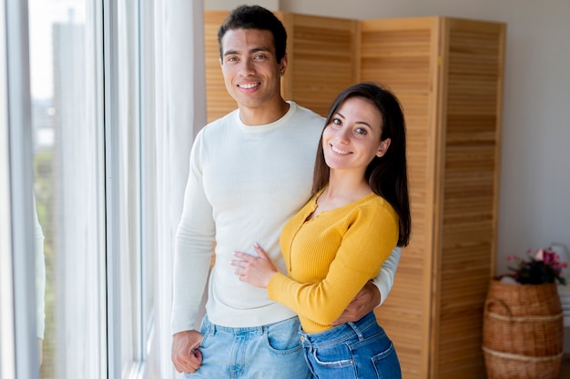 Foto gratuita vista frontal de una pareja encantadora al lado de la ventana