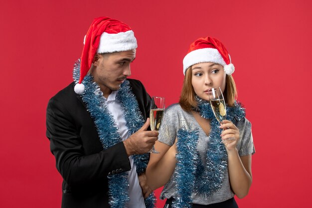 Vista frontal pareja joven celebrando el año nuevo en la fiesta de amor de escritorio rojo navidad