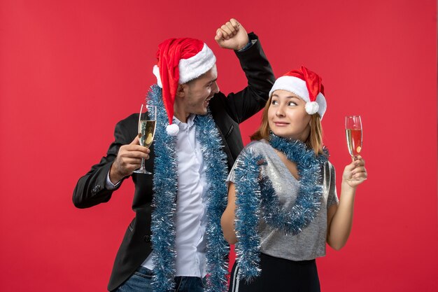 Vista frontal pareja joven celebrando el año nuevo en una fiesta de escritorio rojo amor de navidad