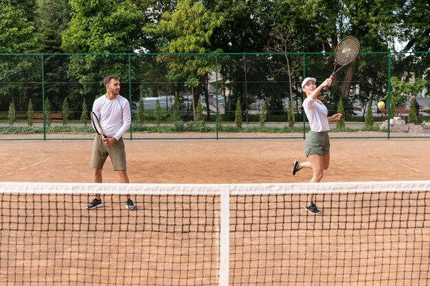 Vista frontal pareja jugando tenis